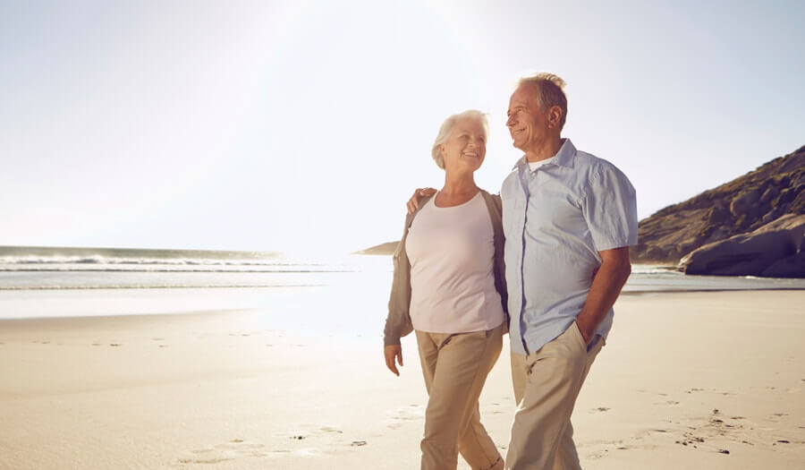 image of a couple walking together on a beach smiling for page when a death occurs