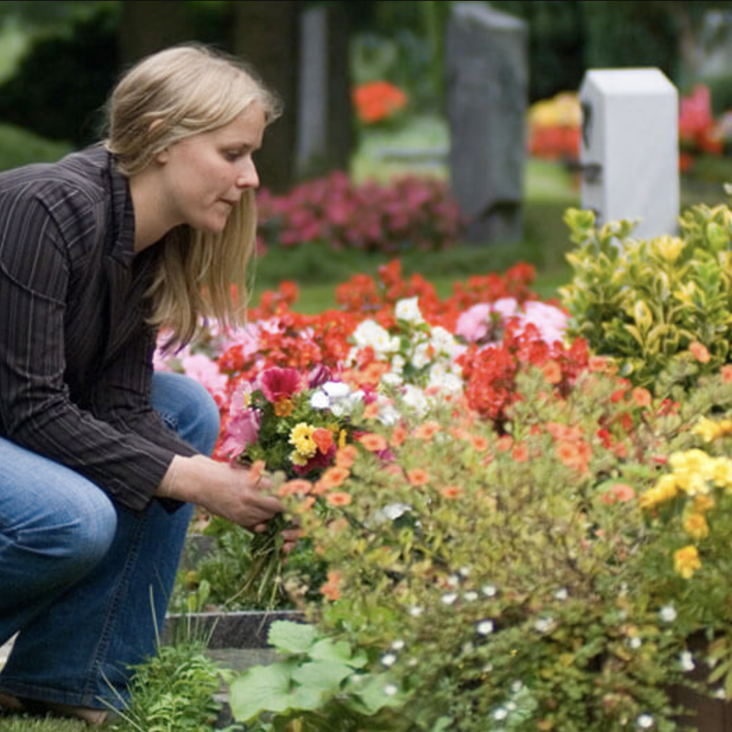 putting flowers on grave
