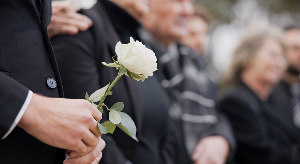 Funeral, person holding white rose